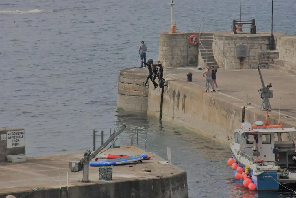 a group of people standing on a dock with a boat at Bellevue Holiday Cottage in Gardenstown