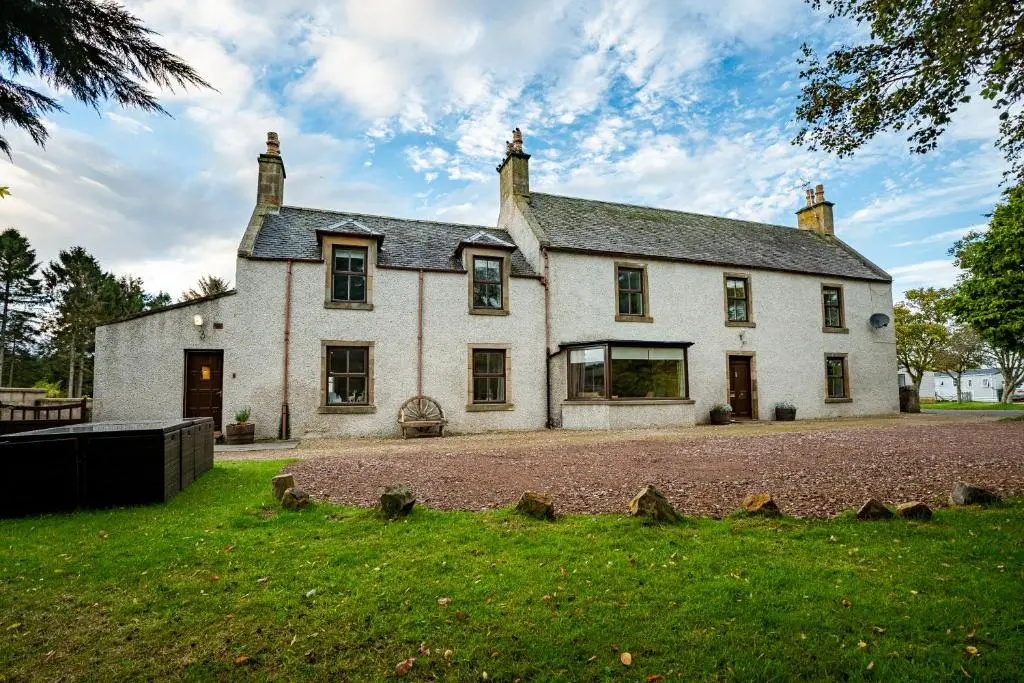 a large white house with a grassy yard at The Farmhouse, 6 bed property, Forres in Forres