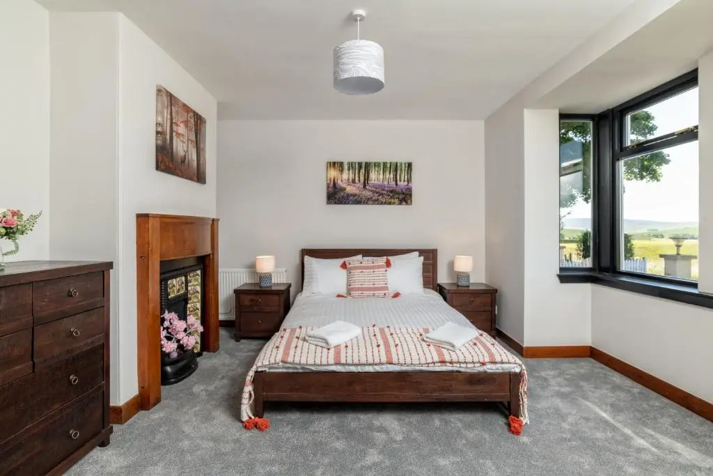 a bedroom with a bed and a fireplace at Stunning, Remodelled Cottage, Picturesque Location in Duncanston