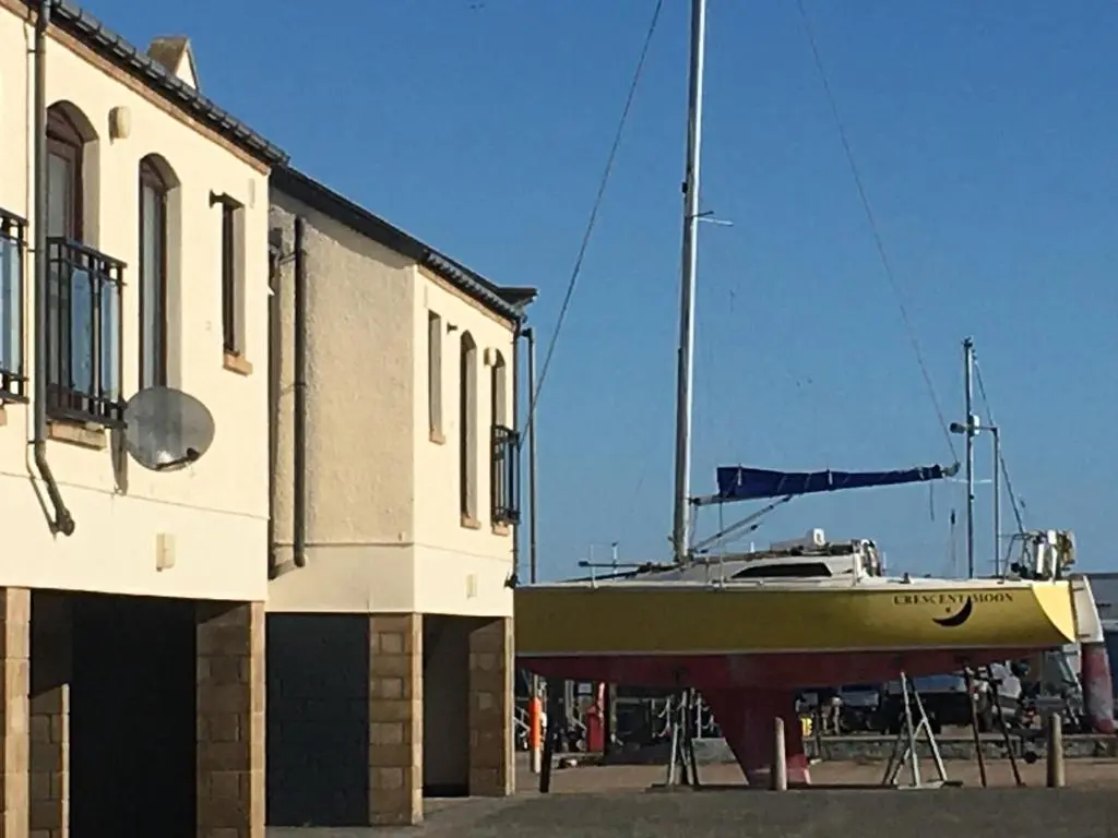 a boat is parked next to a building at Beachfront Panoramic Seaview Free Wifi & Parking in Lossiemouth
