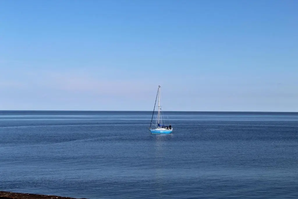 a sail boat in the middle of the ocean at Beachfront Panoramic Seaview Free Wifi & Parking in Lossiemouth