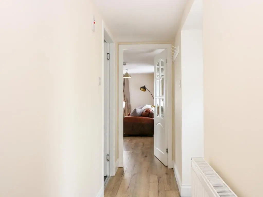 a hallway with white walls and wood floors at The Marriage Room at The Institute Executive Apartments in Keith