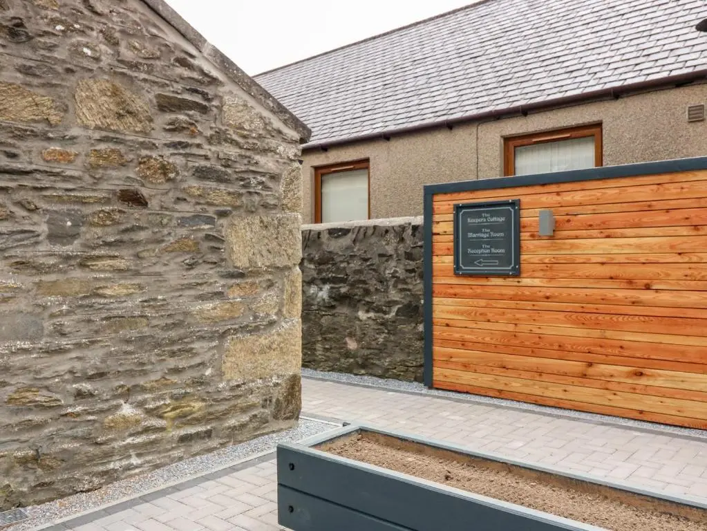 a building with a wooden gate and a stone wall at The Marriage Room at The Institute Executive Apartments in Keith