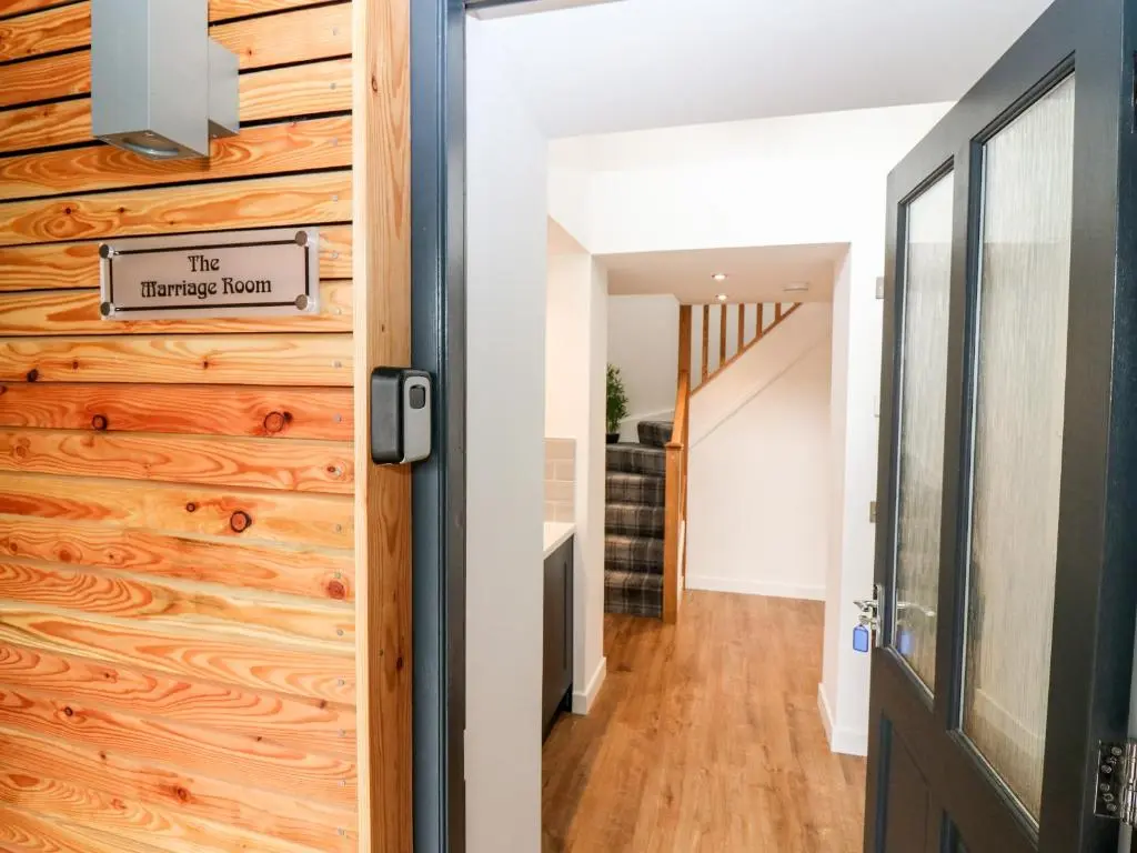 a hallway with a wooden wall and a door at The Marriage Room at The Institute Executive Apartments in Keith