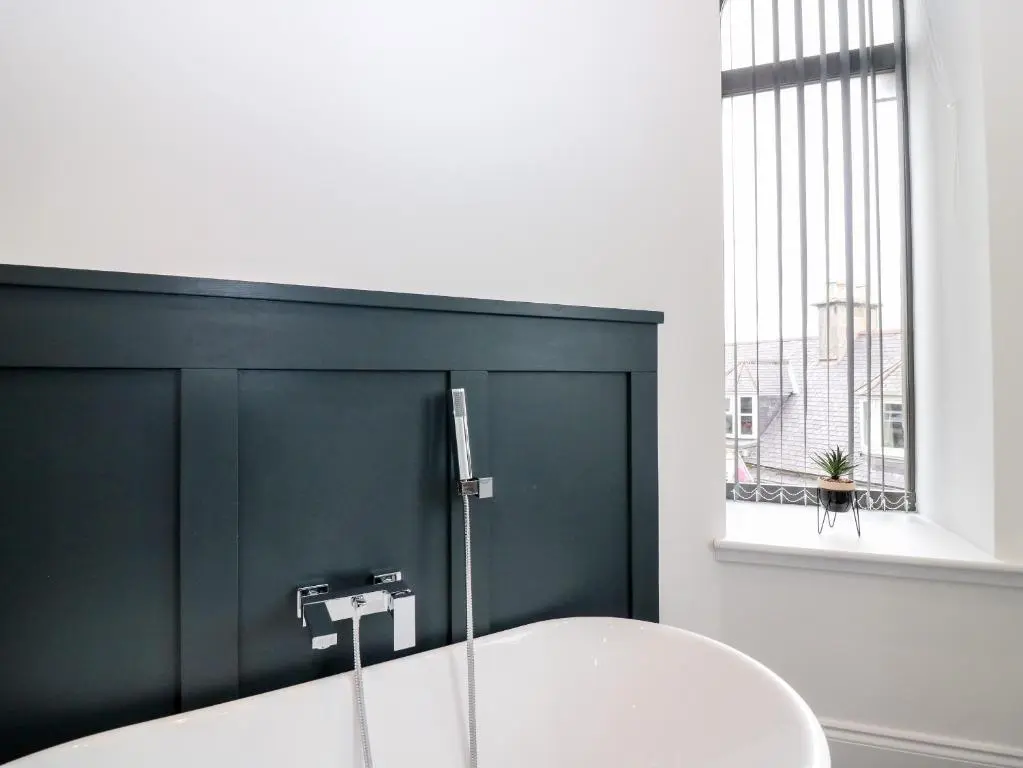 a bathroom with a white sink and a window at The Clock Tower at The Institute Executive Apartments in Keith