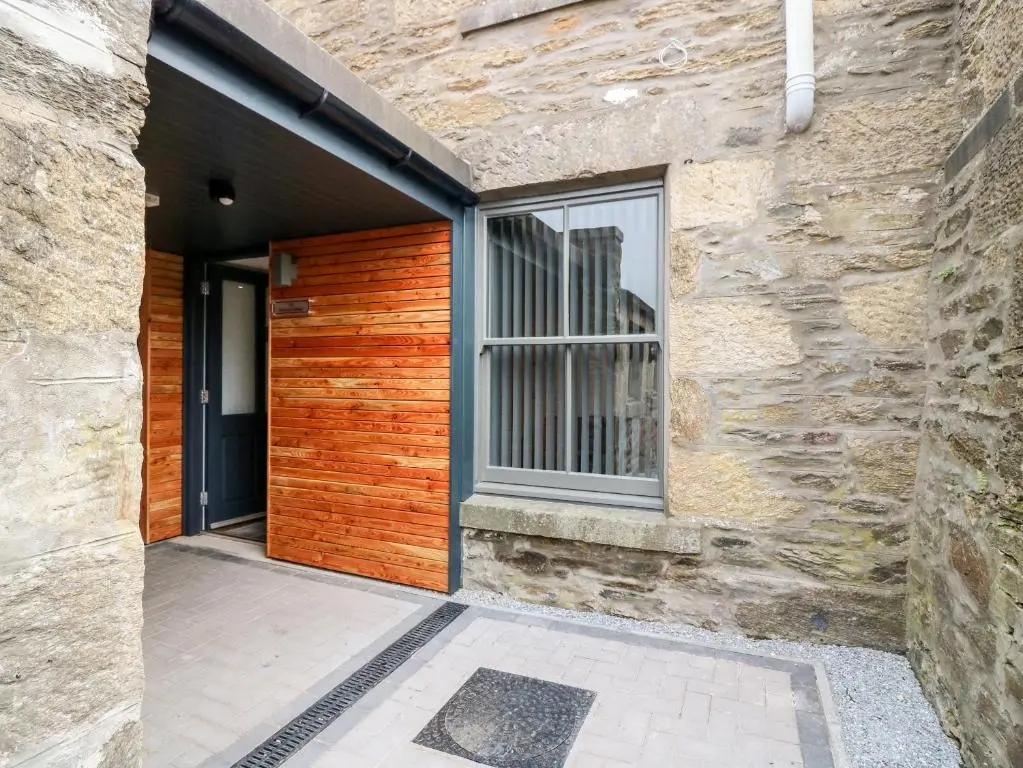 an entrance to a stone building with a wooden door at The Keepers Cottage at The Institute Executive Apartments in Keith