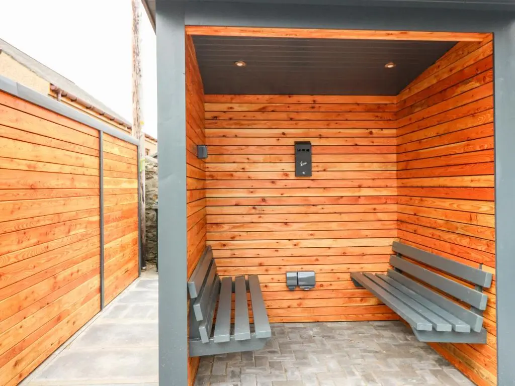 a bench sits in front of a wooden wall at The Court Room at The Institute Executive Apartments in Keith