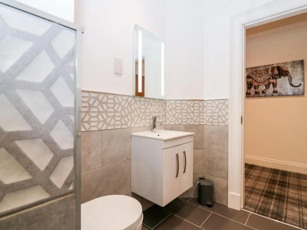 a bathroom with a toilet and a sink at The Court Room at The Institute Executive Apartments in Keith