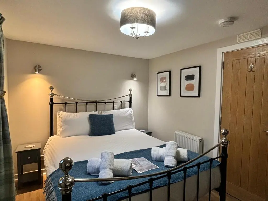 a bedroom with a bed with towels on it at Bracken Lodge 6 with Hot Tub in Belladrum