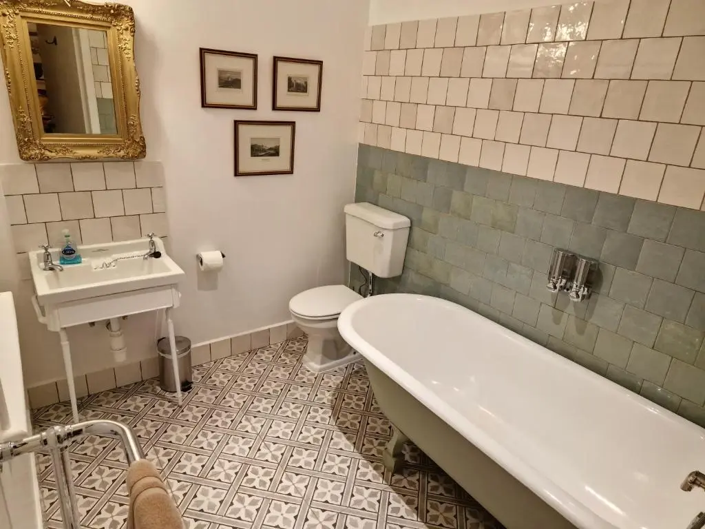 a bathroom with a tub and a toilet and a sink at Cambus O' May Traditional Highland Hotel in Ballater