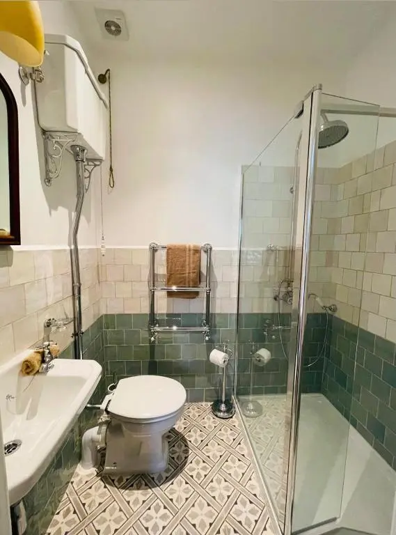 a bathroom with a shower and a toilet and a sink at Cambus O' May Traditional Highland Hotel in Ballater