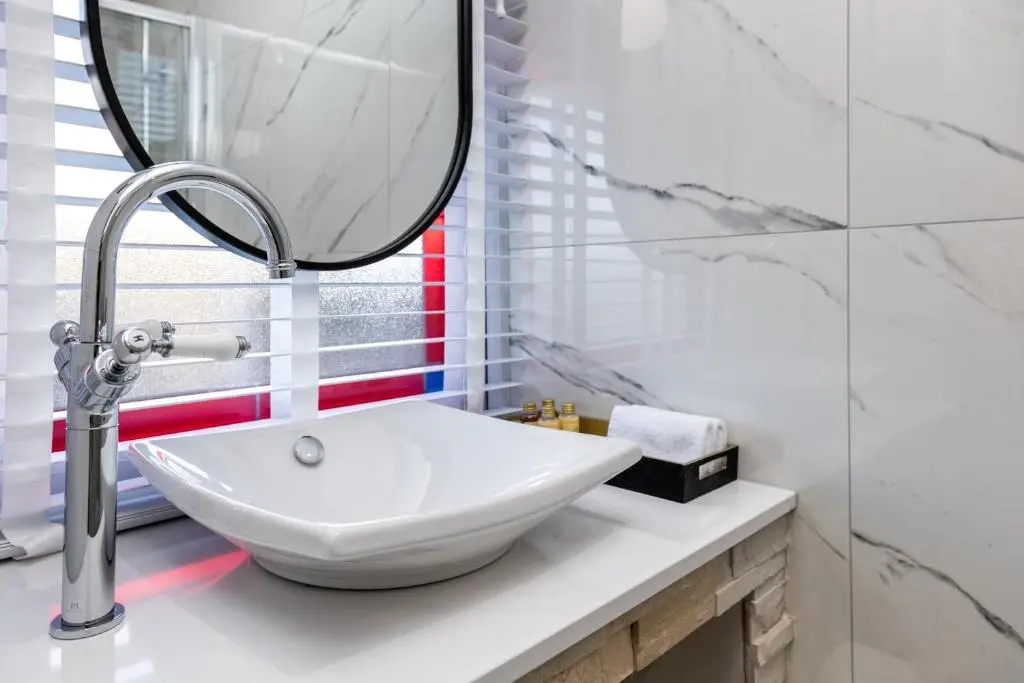 a bathroom with a white sink and a mirror at Pamper yourself in our DOUBLE SIZED copper tub -2 bedroom villa in Inverness