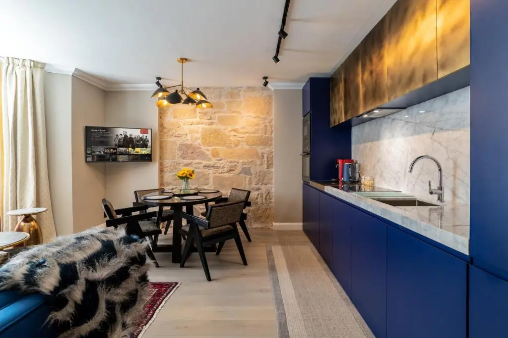 a kitchen and dining room with blue cabinets and a table at Pamper yourself in our DOUBLE SIZED copper tub -2 bedroom villa in Inverness
