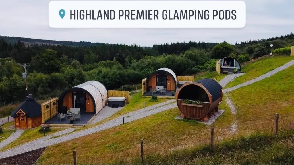 a group of huts on a grassy hill at Highland Premier Glamping Pods in Beauly