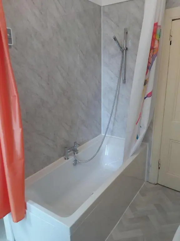 a bathroom with a bath tub with a shower at Kirkhouse in Wick