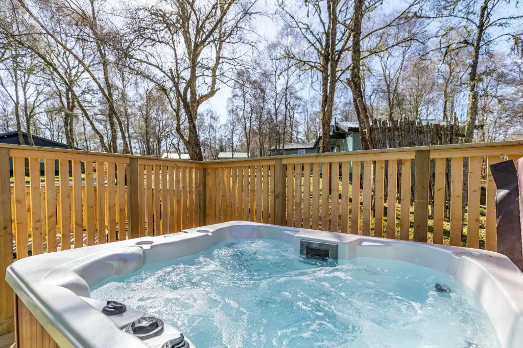 a hot tub on a wooden fence at Heather Lodge 12 with Hot Tub in Belladrum