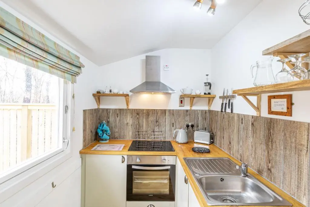 a kitchen with a sink and a stove at Heather Lodge 12 with Hot Tub in Belladrum