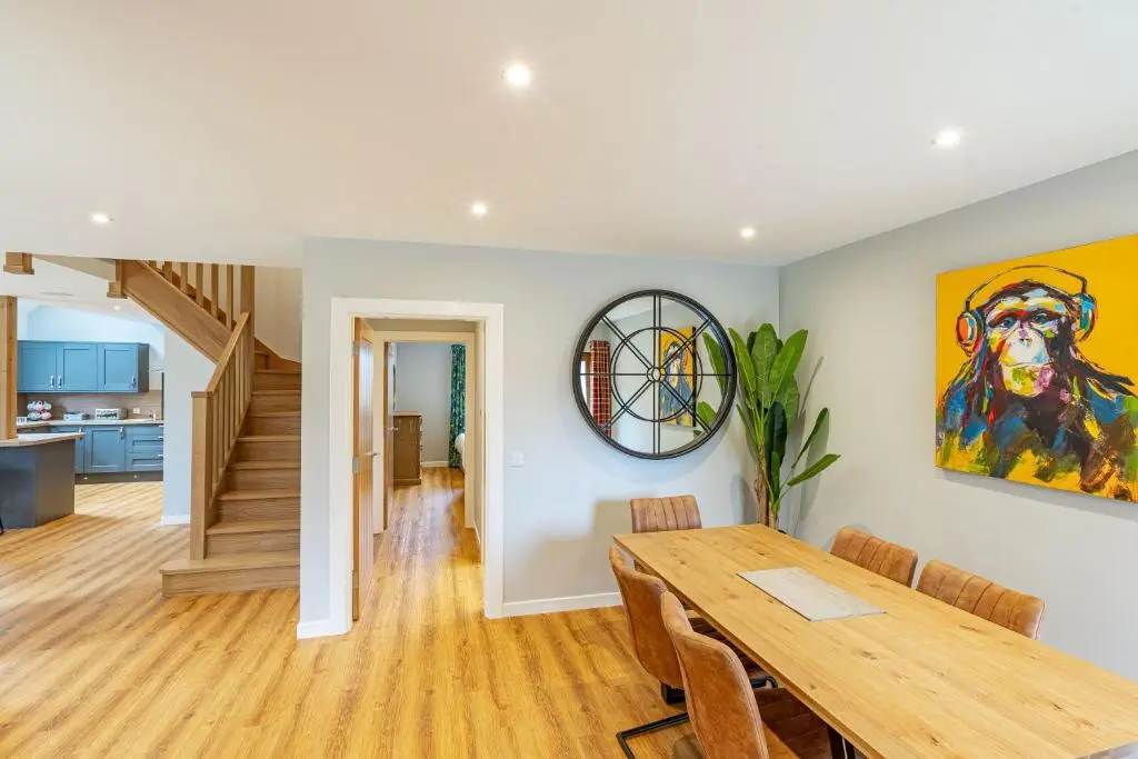 a dining room with a table and a painting on the wall at Monarch Lodge 13 with Hot Tub in Belladrum