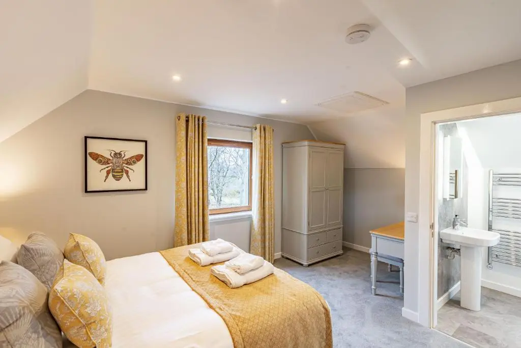 a bedroom with a bed and a sink and a window at Monarch Lodge 13 with Hot Tub in Belladrum