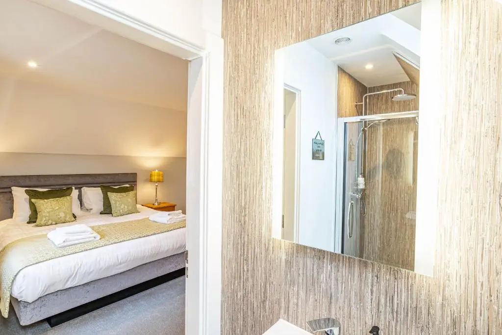 a bedroom with a bed and a mirror at Monarch Lodge 13 with Hot Tub in Belladrum