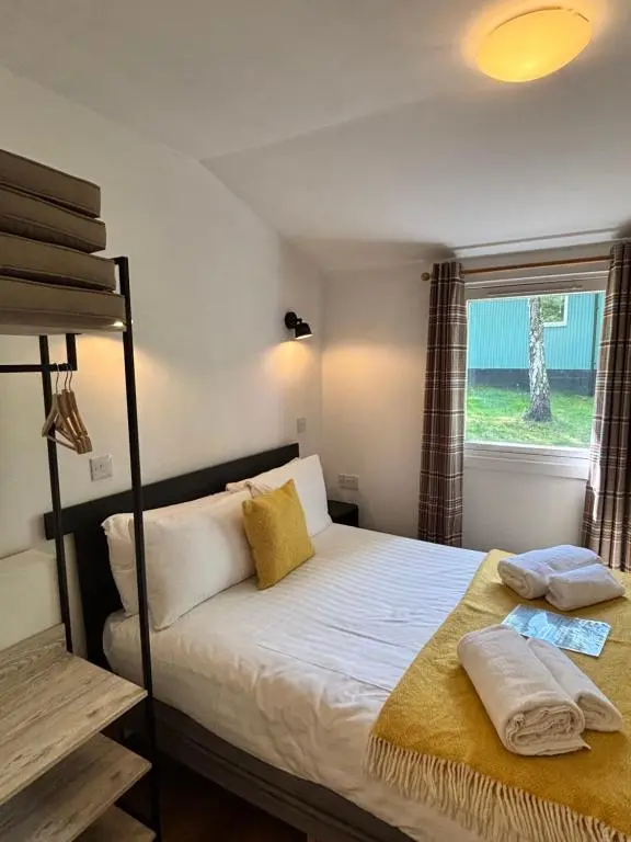 a bedroom with a bunk bed and a window at Fern Lodge 11 with Hot Tub in Belladrum