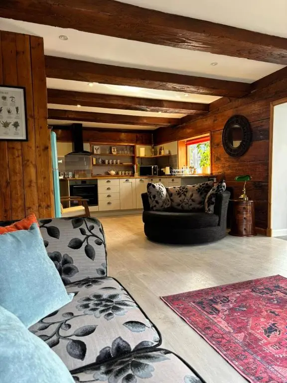 a living room with a couch and a kitchen at Cosy coastal hideaway with incredible sea views in Fortrose