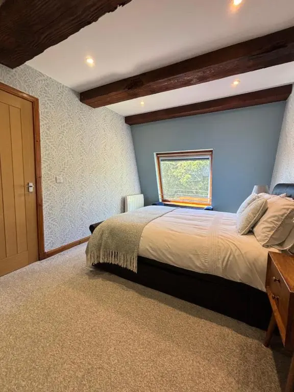 a bedroom with a large bed with a blue wall at Cosy coastal hideaway with incredible sea views in Fortrose