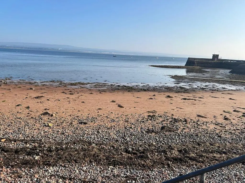 a beach with a pier and the water at Cosy coastal hideaway with incredible sea views in Fortrose