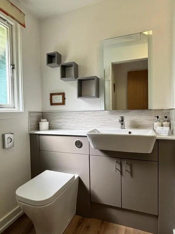 a bathroom with a sink and a toilet and a mirror at Bracken Lodge 8 with Hot Tub in Belladrum