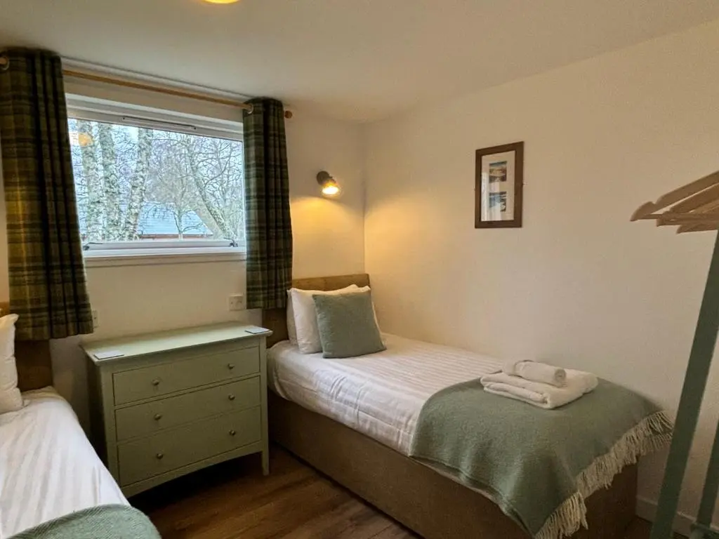 a small bedroom with a bed and a window at Bracken Lodge 16 with Hot Tub in Belladrum