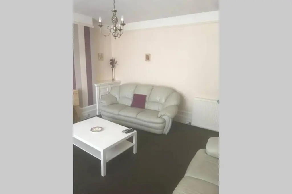 a living room with a couch and a table at Preston Villa, spacious ground floor apartment in Buckie
