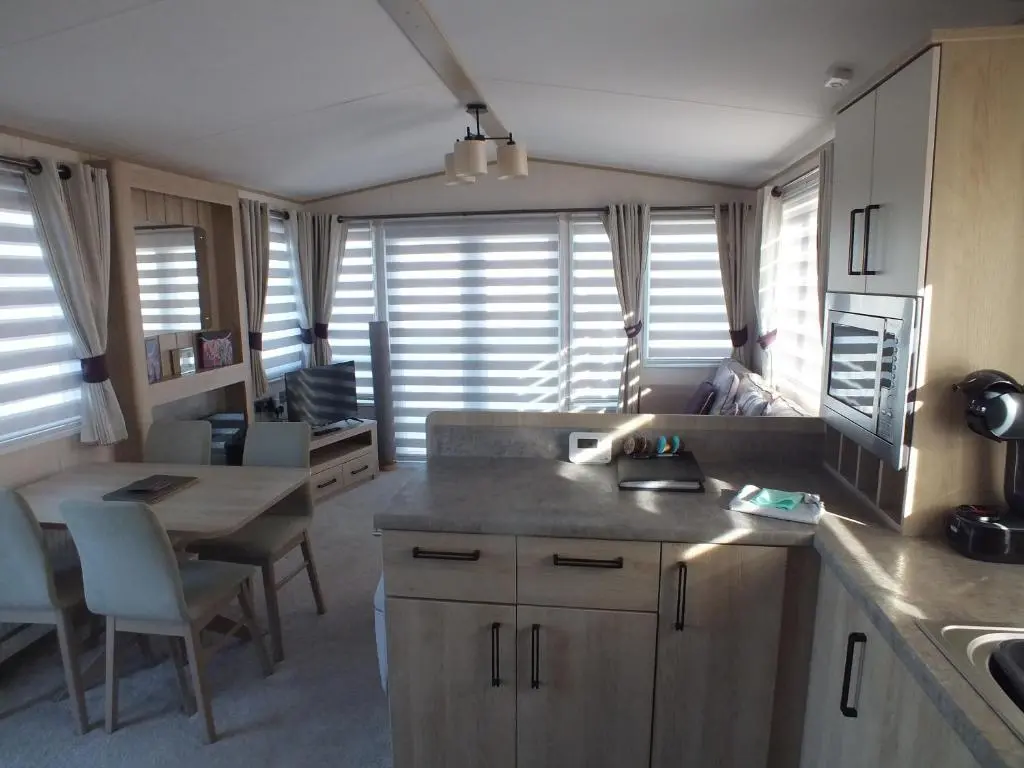 a kitchen with a sink and a table with a counter top at Beachside Lighthouse 14 in Lossiemouth