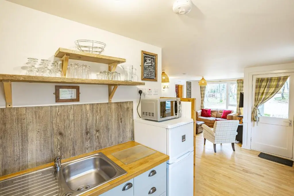 a kitchen with a sink and a microwave at Heather Lodge 4, sleeping 6 in Belladrum