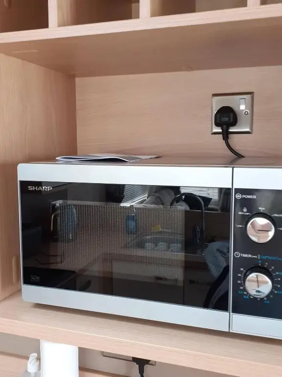 a microwave oven sitting on top of a shelf at RICK'S RETREAT static caravan near the beach with free wifi in Lossiemouth
