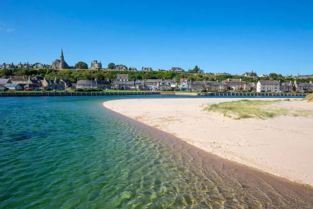 a view of a beach with houses in the background at RICK'S RETREAT static caravan near the beach with free wifi in Lossiemouth