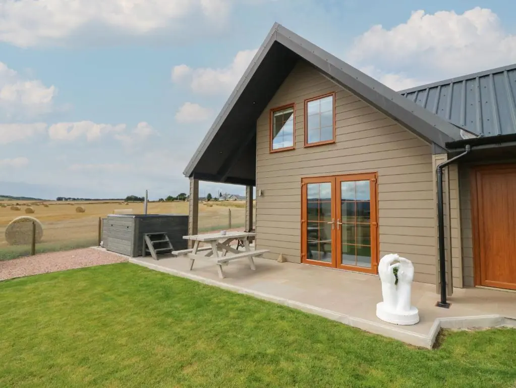 a small house with a picnic table and a grill at Garden Studio in Insch