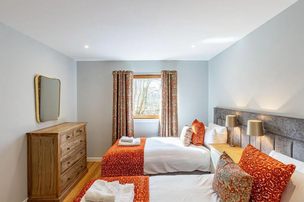 a bedroom with a bed and a mirror at Monarch Lodge 14 with Hot Tub in Belladrum