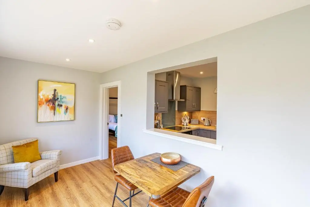 a kitchen and dining room with a table and chairs at Thistle Lodge 22 with Hot Tub in Belladrum