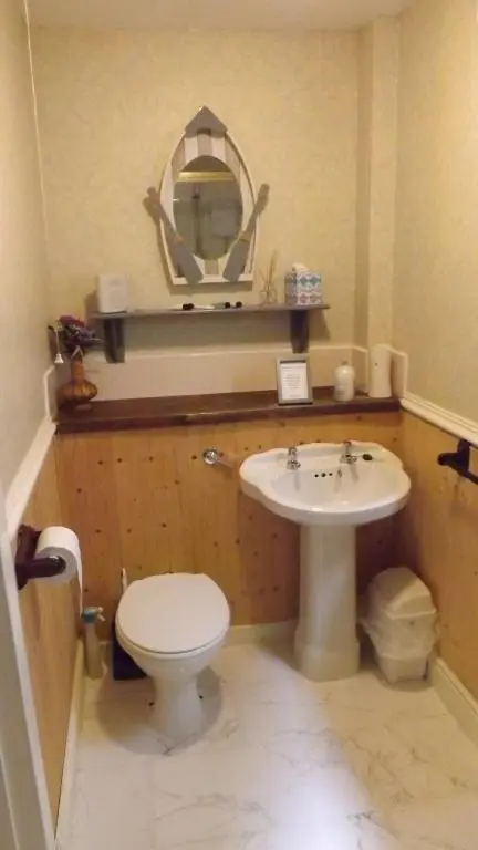 a bathroom with a sink and a toilet and a mirror at Small cosy bothy in Dingwall