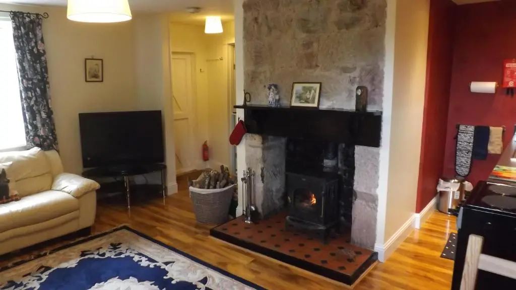a living room with a fireplace and a couch at Small cosy bothy in Dingwall