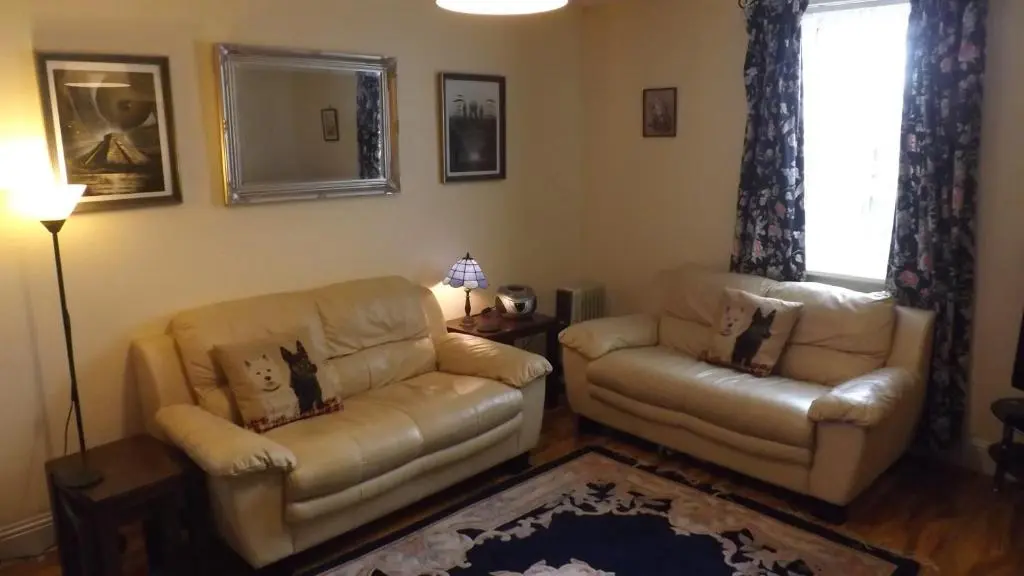 a living room with a couch and a chair at Small cosy bothy in Dingwall