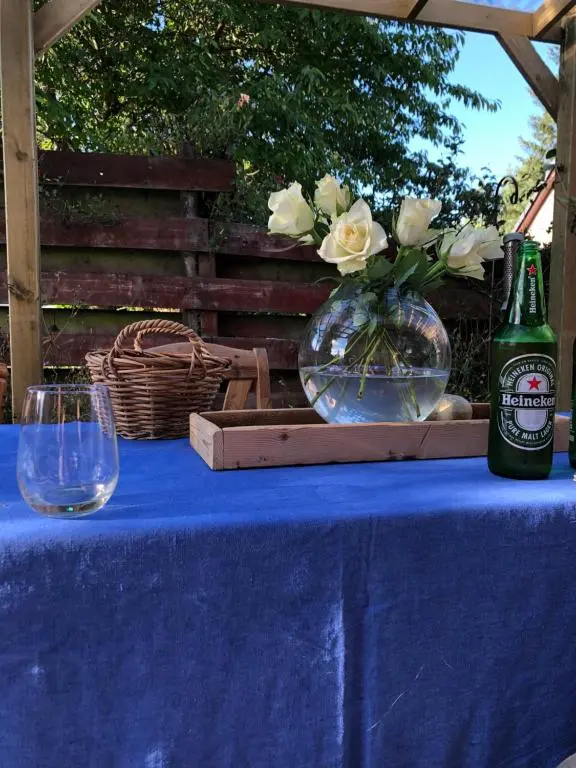 a bottle of beer and a vase with flowers on a table at Nurse's Cottage in Tomintoul