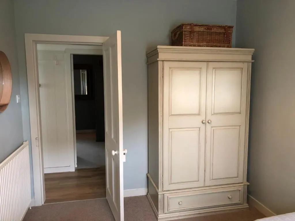a white cabinet in a room with a hallway at Nurse's Cottage in Tomintoul