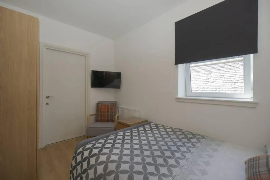 a bedroom with a bed and a window at Town centre 4xbed 4xbath apartment in Elgin