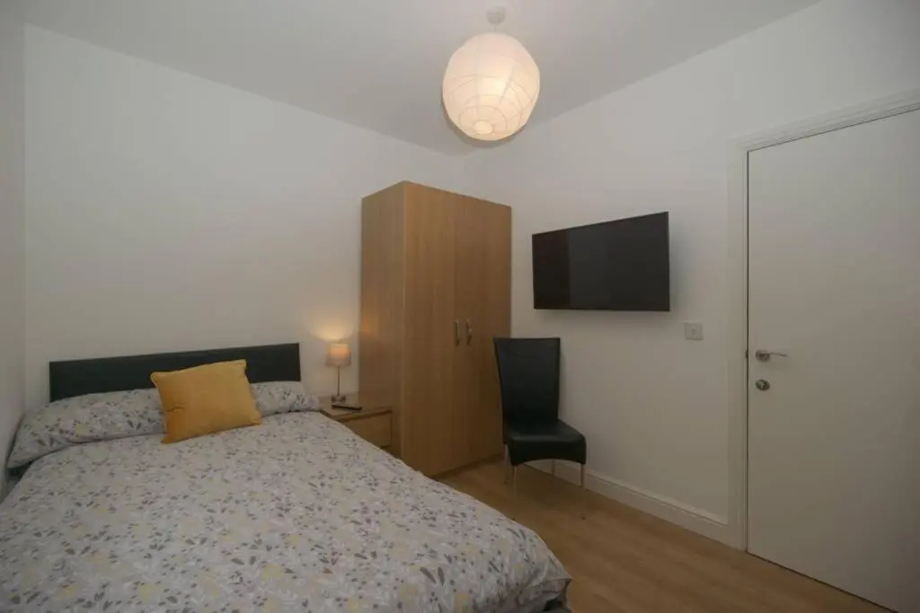 a bedroom with a bed and a flat screen tv at Town centre 4xbed 4xbath apartment in Elgin