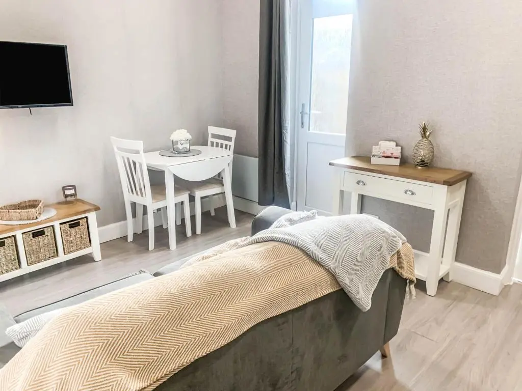 a bedroom with a bed and a table and a television at The Rosebery Retreat By The Castle 1-Bed Apartment in Inverness