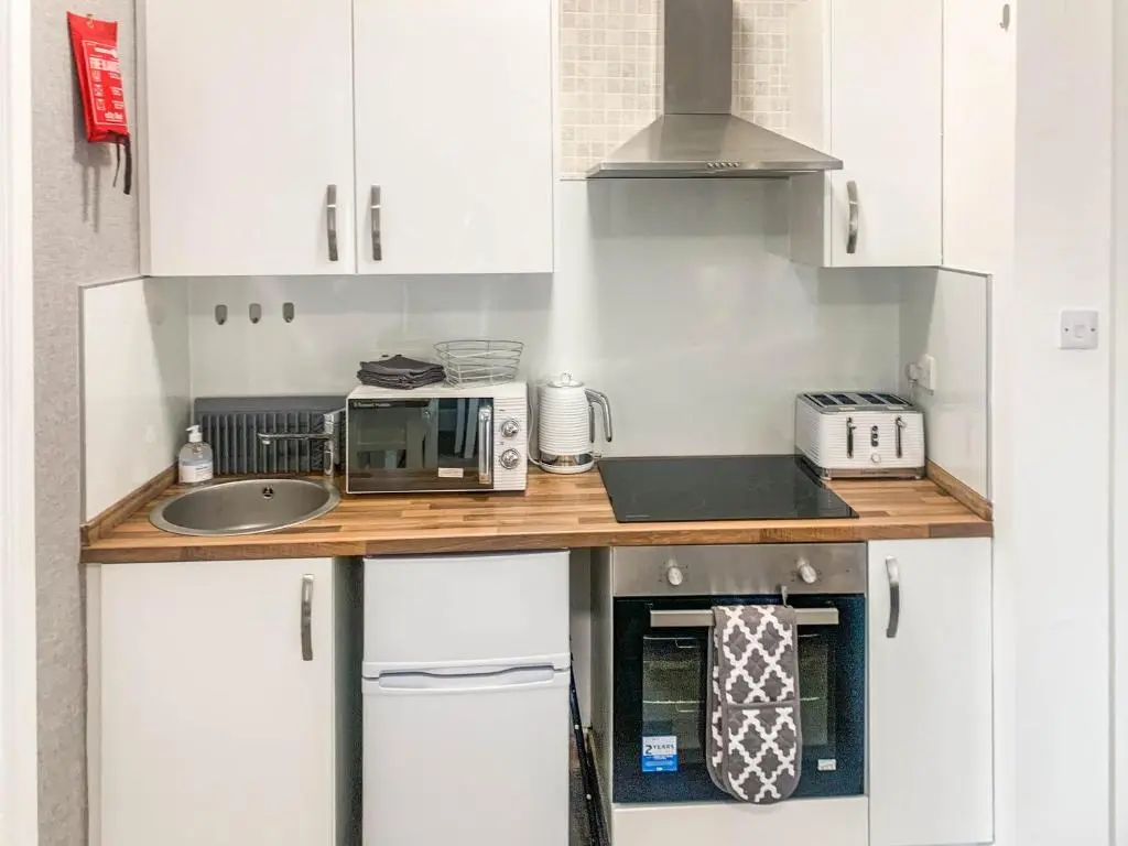 a kitchen with a counter with a microwave and a sink at The Rosebery Retreat By The Castle 1-Bed Apartment in Inverness