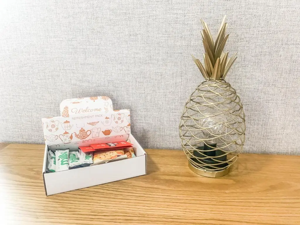 a pineapple next to a box of cookies and a box of candy at The Rosebery Retreat By The Castle 1-Bed Apartment in Inverness