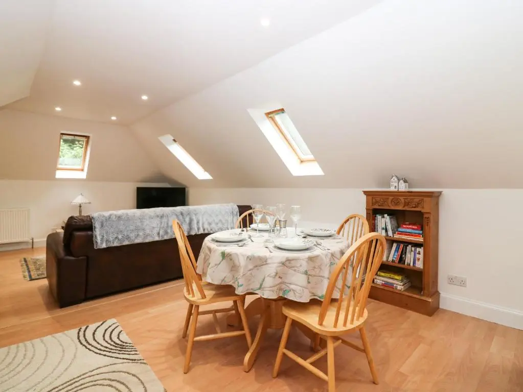a dining room with a table and chairs and a couch at Hayloft in Peterhead