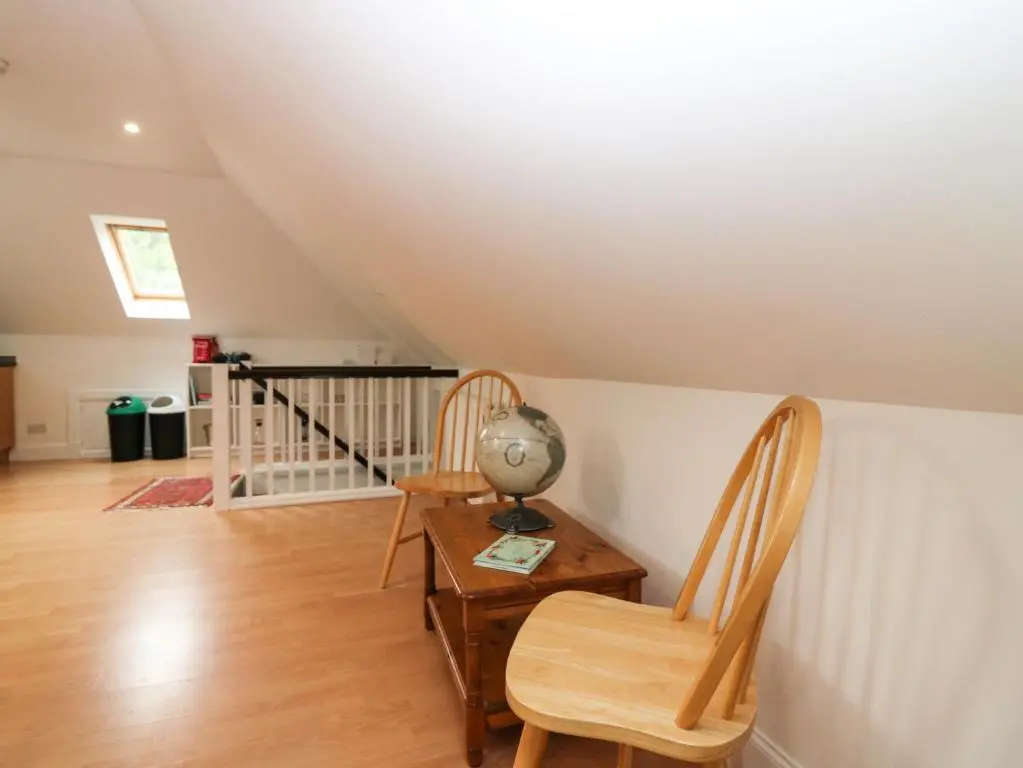 a room with a desk and two chairs and a stairs at Hayloft in Peterhead